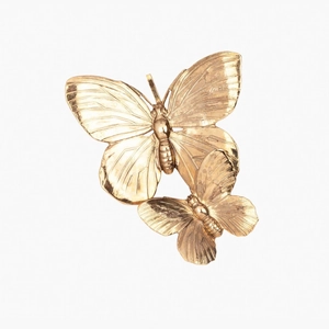 Macro detail of the golden 3D metallic butterfly hair clip showing fine textures