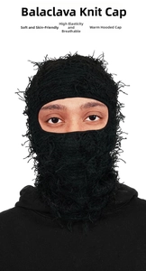 Close-up of black knitted balaclava featuring distressed tassel texture and soft fuzzy yarn