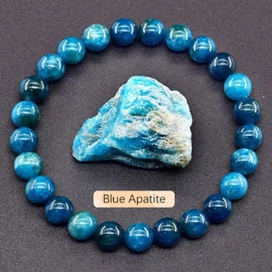 Detail of natural blue apatite beaded bracelet with rough crystal stone on textured background