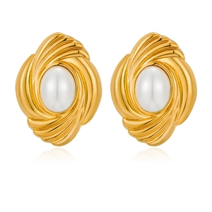 Detailed view of vintage gold swirl earrings with inlaid pearls on a white background