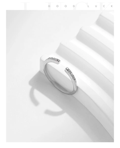 Detail of 925 sterling silver open ring with micro-set diamonds on geometric wavy stand