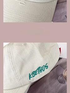 Close-up of fine stitching on the brim and dark green embroidery on a beige baseball cap