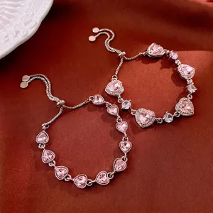 Adjustable rose gold heart bracelet with pink zircon crystals on silk background
