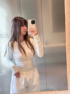 Detail shot of white ribbed long sleeve top and elastic waist joggers in a mirror selfie