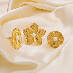Three-piece 18K gold plated stainless steel ring set with elegant pearl accents on silk