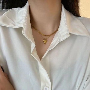 Double-layered gold heart pendant necklace featuring a wide flat snake bone chain
