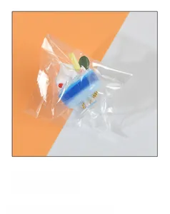 Close-up of a miniature blue cream sundae keychain with white frosting and red beads