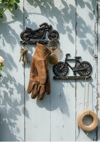 Detalle de ganchos de pared de hierro fundido vintage con moto y bicicleta, llaves y guantes
