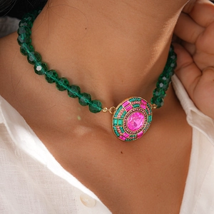 Gros plan d'un collier vintage en perles vertes avec pendentif en pierre rose
