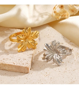Detailed shot of gold and silver flower rings on silk with adjustable band