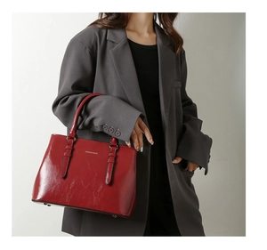Detail of red oil wax leather handbag with FASHION & BAGS logo and dual handles