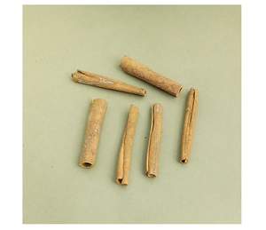 Top view of six natural dried cinnamon sticks for Christmas DIY decor on green background