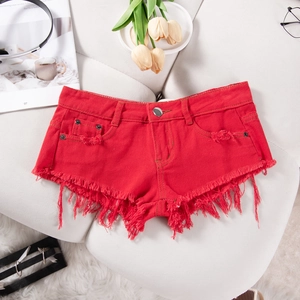 Detail der roten High-Waist Denim Shorts mit stark ausgefransten Säumen und Troddel-Deko