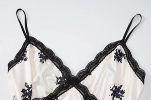 Détail d'une robe en satin à imprimé floral avec dentelle noire et fines bretelles