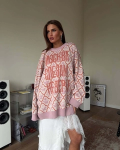 Detail of pink knitted oversized sweater with white jacquard patterns and Russian text