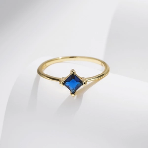 Minimalist S925 sterling silver ring with square blue gemstone on a soft curved background