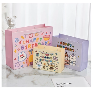 Drei bunte Cartoon-Geschenktüten aus Papier mit Griffen und Happy Birthday Motiven
