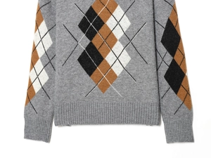 Dettaglio dell'orlo a coste e del maglione grigio a rombi argyle color caramello