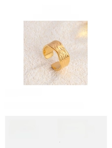 Macro shot of gold-plated titanium steel C-shape ring with feather textured details