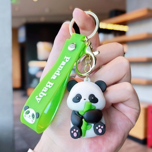 Detail of cute panda keychain with bamboo and Panda Baby green silicone strap