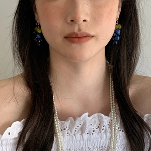 Detailed close-up view of elegant resin grape cluster tassel earrings worn by a model