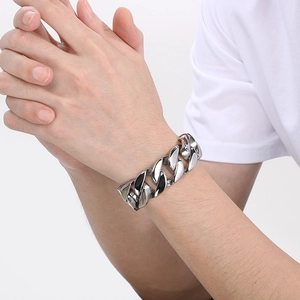 Close-up of 22mm thick silver Cuban chain bracelet worn on male wrist