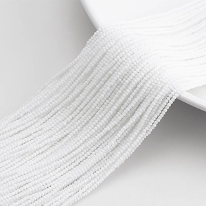 Detailed macro shot of 32-facet white crystal glass beads arranged in elegant rows