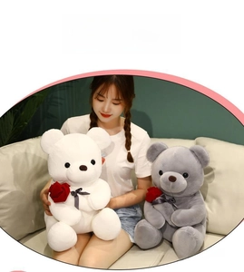 Close-up of soft plush teddy bear with decorative rose in a cozy home setting