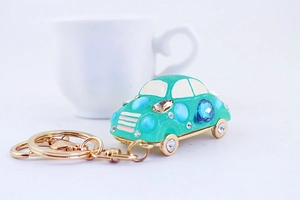 Detailed macro view of a light green car keychain with colorful rhinestones and gold ring