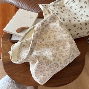 Detailaufnahme kleiner Stoffbeutel mit Blumenmuster und Etikett auf einem Holztisch