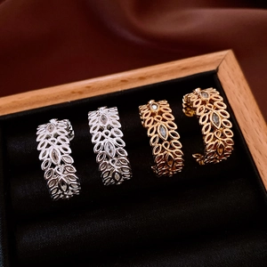 Macro detail of 18K gold and silver wheat ear earrings with cubic zirconia in a velvet box