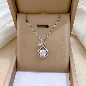 Elegant fishtail drop pendant necklace with pavé diamonds in a silk jewelry box