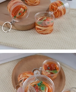 Macro view of realistic miniature beef noodle cup keychain with detailed soup and toppings