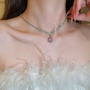 Detail of luxury teardrop pink diamond pendant necklace on model with sparkling accents