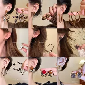 Detail showing leopard print earrings in various shapes like stars and hearts on models