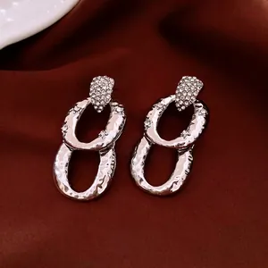 Geometric oval drop earrings with micro-pave zircons and hammer textured silver finish