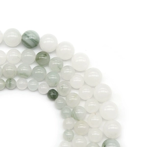 Vue détaillée de perles rondes en pierre naturelle vert clair et blanc en rangées