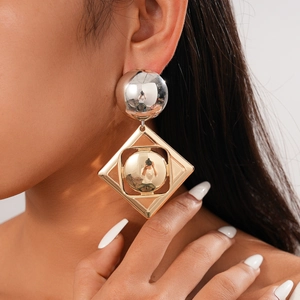 Detail of oversized gold and silver geometric earrings on model with metallic finish