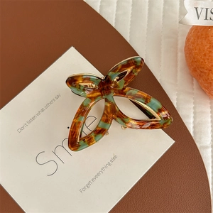 Detailed macro view of the butterfly hair claw clip with faux tortoiseshell and gold trim