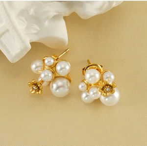 Detailed shot of pearl cluster stud earrings with gold base and floral crystal accents