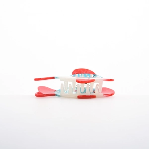 Macro detail of tropical fish hair claw clip with nautical red, white, and blue stripes