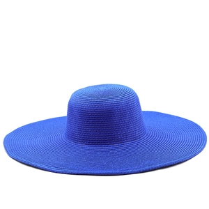 Detail of royal blue straw hat featuring intricate woven texture and wide sun brim