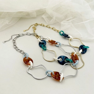 Close-up of colorful resin rings on gold and silver stainless steel pig nose chain