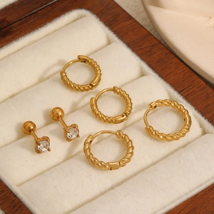 Three-piece titanium steel earring set with twisted gold hoops and stud earrings in box