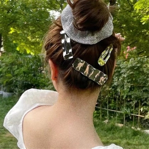 Chic silver metal hair clips set on woman hairstyle in outdoor natural light setting