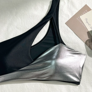 Close-up of metallic silver and black fabric stitching with hollow cutout detail on bikini