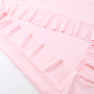Detail shot of pink dress fabric showing ruffled hem and high-quality polyester texture