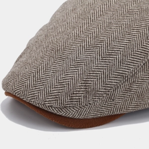 Macro shot of gray herringbone fabric texture and contrast brim on vintage flat cap
