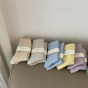 Close-up of five pairs of pastel cotton ribbed socks with Loulor paper packaging