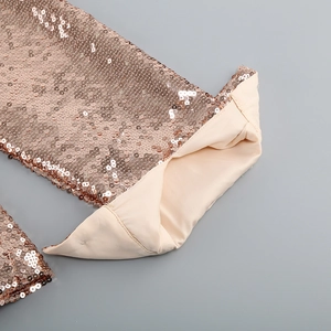 Close-up of sparkling rose gold sequins and soft beige lining on a two-piece skirt set